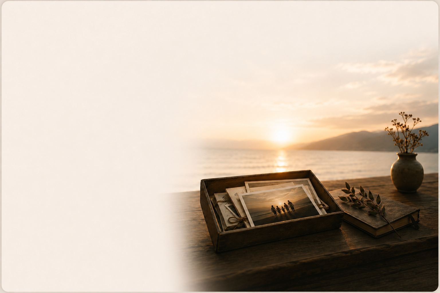 A wooden box of family photographs beside a journal at sunset